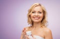 Happy middle aged woman with cream jar Royalty Free Stock Photo