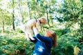 Happy middle-aged woman embracing her cockapoo puppy pet dog during walk outdoors in summer forest or park on sunset. Cute little Royalty Free Stock Photo