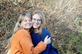 Happy middle aged woman enjoying love of her teenage daughter on Mother`s Day. Portrait of hugging mother and daughter, outdoors