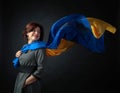 Happy middle-aged woman in a gray dress with a blue and yellow shawl Royalty Free Stock Photo