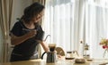 Happy middle aged woman preparing coffee for breakfast in comfortable home kitchen. Retirement, Healthy seniors lifestyle Royalty Free Stock Photo