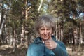 Happy middle-aged woman showing thumbs up, standing on the street in the park, focus on the face.Recommendations concept Royalty Free Stock Photo