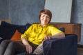 Happy middle aged woman sitting on sofa at home Royalty Free Stock Photo