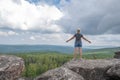 A happy middle-aged woman stands on the top of a mountain enjoying an amazing view.Active recreation and travel concept Royalty Free Stock Photo