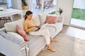Happy middle aged woman using laptop computer sitting on sofa at home. Royalty Free Stock Photo
