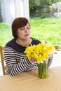 Happy middle aged woman with yellow bouquet