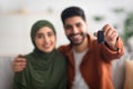 Happy Middle Eastern Couple Showing Automobile Key To Camera Indoors Royalty Free Stock Photo