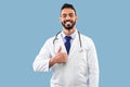 Happy Middle Eastern Doctor Man Gesturing Thumbs-Up Posing Over Blue Background Royalty Free Stock Photo