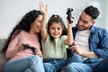 Happy middle eastern family of three playing video games together at home Royalty Free Stock Photo