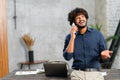 Happy middle eastern man talking on the smartphone while standing in modern loft office. Smiling successful contemporary Royalty Free Stock Photo