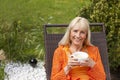 Happy middleage woman relaxing with coffee Royalty Free Stock Photo