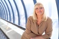 Happy middleaged businesswoman near glass wall