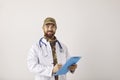 Happy military doctor in camouflage hat and medical lab coat holding clipboard and smiling