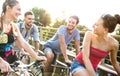 Happy millenial friends having fun riding bicycle in city park - Friendship concept with young millennial people students biking Royalty Free Stock Photo