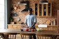 Happy millennial African American young man cooking salad in kitchen Royalty Free Stock Photo