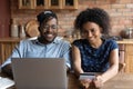 Happy millennial African couple shopping on internet together