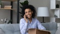 Happy millennial african woman talking on cellphone, shopping online. Royalty Free Stock Photo