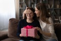 Happy young woman presenting wrapped gift to old mother. Royalty Free Stock Photo