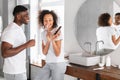 black couple brushing teeth using mobile phone in modern bathroom Royalty Free Stock Photo