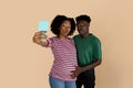 Happy millennial black husband touching woman belly, have fun, enjoy pregnancy, take selfie on phone, photo Royalty Free Stock Photo