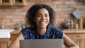 Happy millennial Black woman laughing at laptop at home Royalty Free Stock Photo