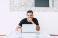 Happy millennial business young man sit on his desk with modern technology computer laptop smiling at the camera - minimalism. Royalty Free Stock Photo