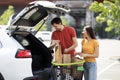 Happy millennial couple loading purchases after shopping into car trunk Royalty Free Stock Photo