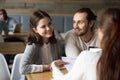 Happy millennial couple planning to sign mortgage contract at me