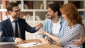 Happy millennial couple receiving keys from realtor, purchasing real estate Royalty Free Stock Photo