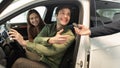 Happy millennial couple taking car key from auto salesman, sitting inside modern automobile at dealership, panorama Royalty Free Stock Photo