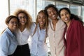 Happy millennial diverse biracial female employees looking at camera.