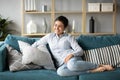 Happy millennial ethnic girl relaxing on sofa at home Royalty Free Stock Photo