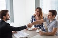 Happy millennial couple and realtor shake hands making property deal Royalty Free Stock Photo