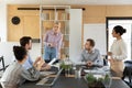 Happy millennial female team leader holding brainstorming meeting with colleagues. Royalty Free Stock Photo