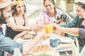 Happy millennial friends cheering at breakfast brunch meal in nature outdoor - Young people having fun together eating fruits and Royalty Free Stock Photo