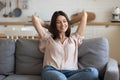 Happy millennial girl relax on comfortable sofa at home Royalty Free Stock Photo