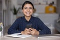 Happy millennial Indian ethnic girl chatting online on mobile phone Royalty Free Stock Photo