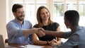 Happy millennial married couple shaking hands with financial advisor. Royalty Free Stock Photo