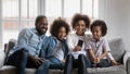 Happy millennial parents and children using smartphone