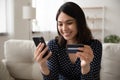 Happy Vietnamese woman shopping online on cellphone Royalty Free Stock Photo