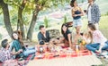 Happy millennials friends haing picnic bbq dinner outdoor - Young people eating and drinking wine in summer weekend day - Royalty Free Stock Photo