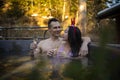 Happy mixed race couple in jacuzzi swimming pool on resort spa pampering romantic weekend getaway for honeymoon vacation during wi Royalty Free Stock Photo