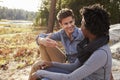 Happy mixed race couple talking in the countryside