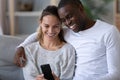 Happy mixed race couple using phone taking selfie on sofa Royalty Free Stock Photo