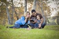 Happy Mixed Race Ethnic Family Playing with Bubbles In The Park Royalty Free Stock Photo