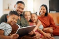 A happy mixed race family of five relaxing on the sofa at home. Loving black family being affectionate on the sofa while