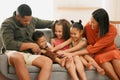 A happy mixed race family of five relaxing on the sofa at home. Loving black family being playful on the sofa. Young