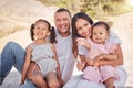 A happy mixed race family of four enjoying fresh air at the beach. Hispanic couple bonding with their daughters while Royalty Free Stock Photo