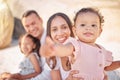 A happy mixed race family of four enjoying fresh air at the beach. Hispanic couple bonding with their daughters while Royalty Free Stock Photo