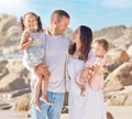 A happy mixed race family of four enjoying fresh air at the beach. Hispanic couple bonding with their daughters while Royalty Free Stock Photo